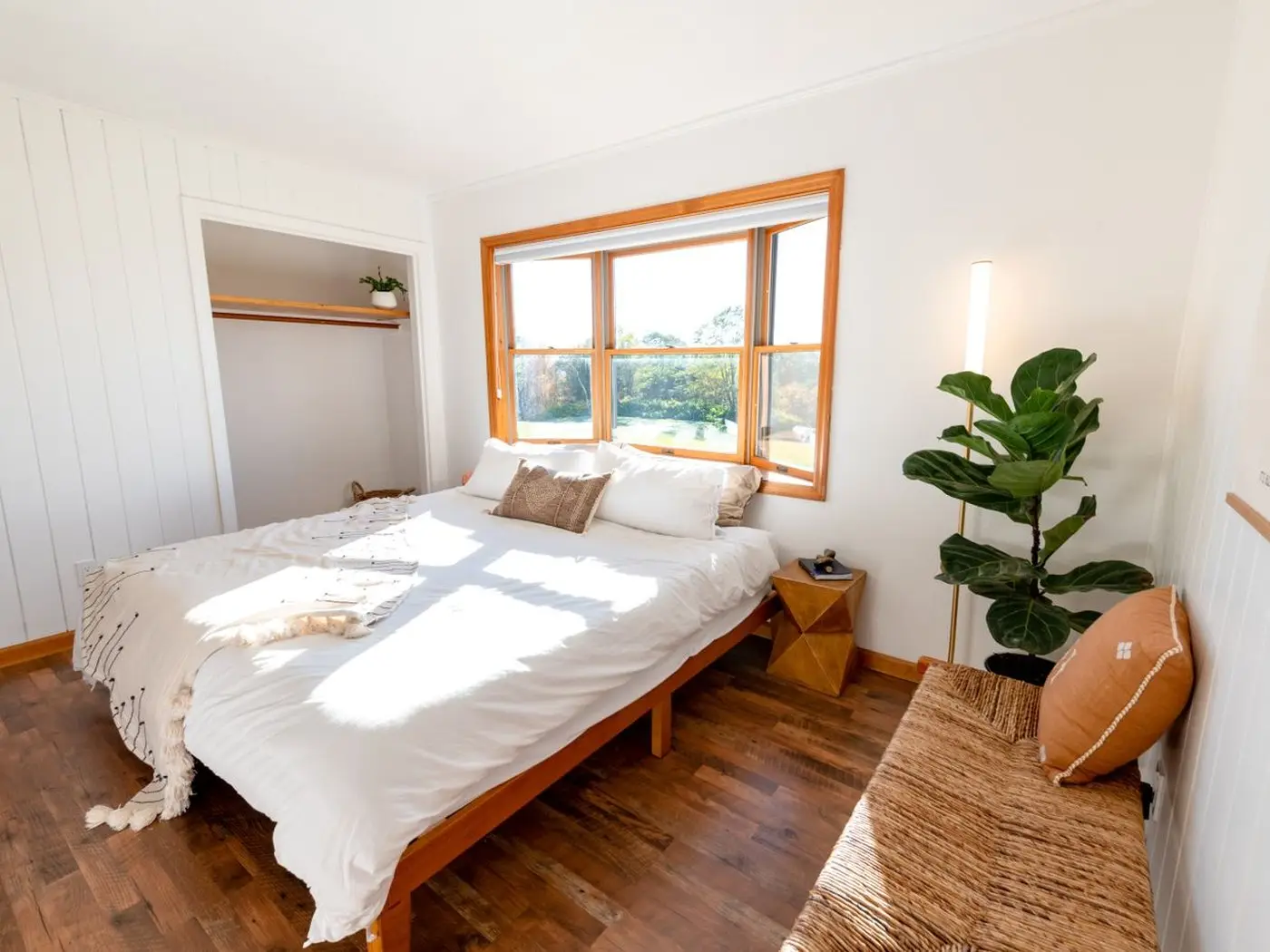 Double bed in a bright timber-clad holiday-home bedroom
