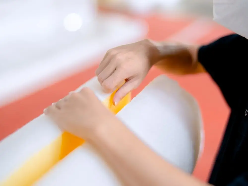 Close-up of hands shaping polyurethane foam for bespoke mattress making